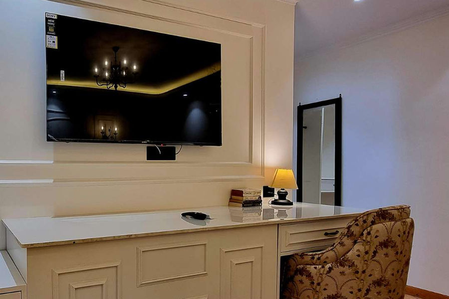 In-room 55-inch Smart TV with work desk, reading lamp and comfortable seating at Akasa Dalhousie luxury homestay